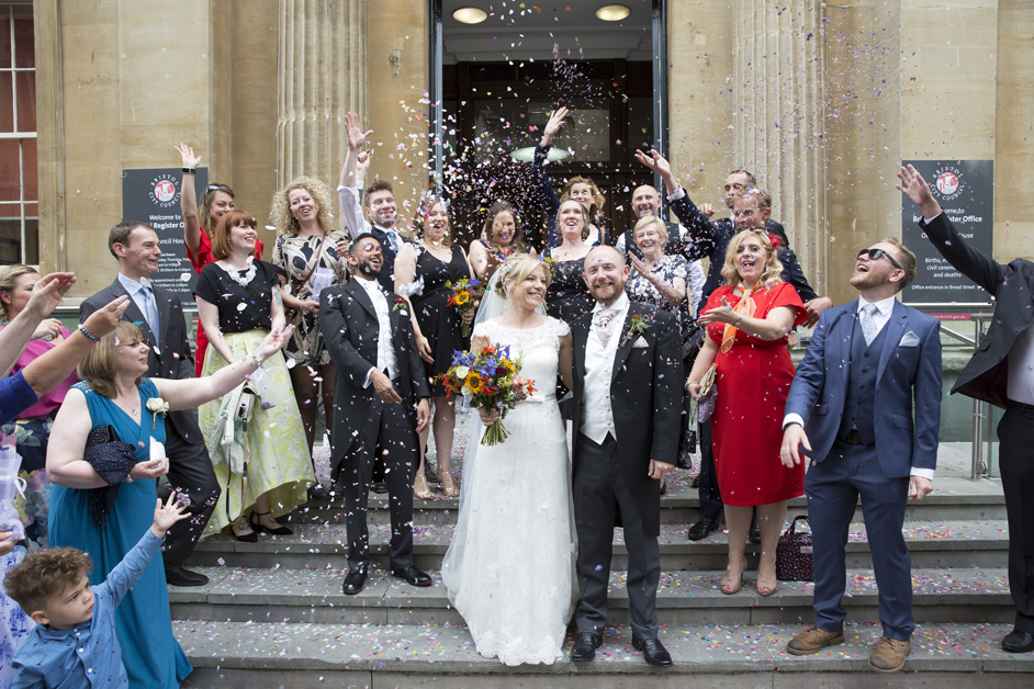 guests throw confetti on bride and groom outside Bristol Register Office