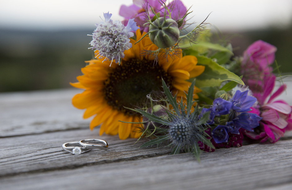 bride's engagement and wedding ring on country bench with sunflower bouquet at Bristol wedding reception at The Ethicurean