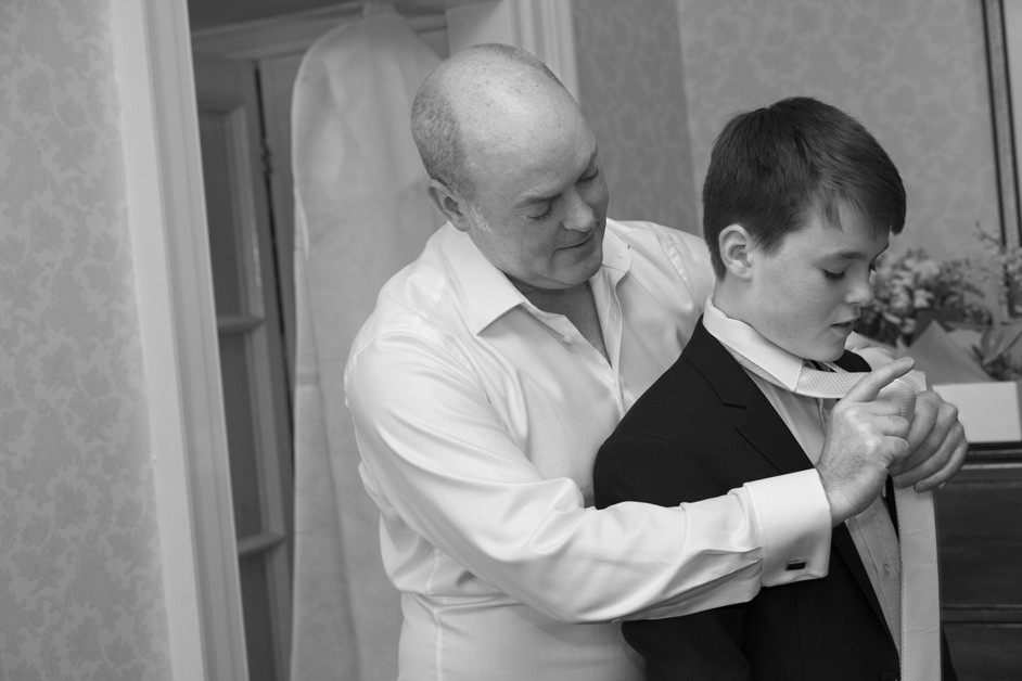 groom helping his son with his tie getting ready before the wedding at The Shelleys in Lewes
