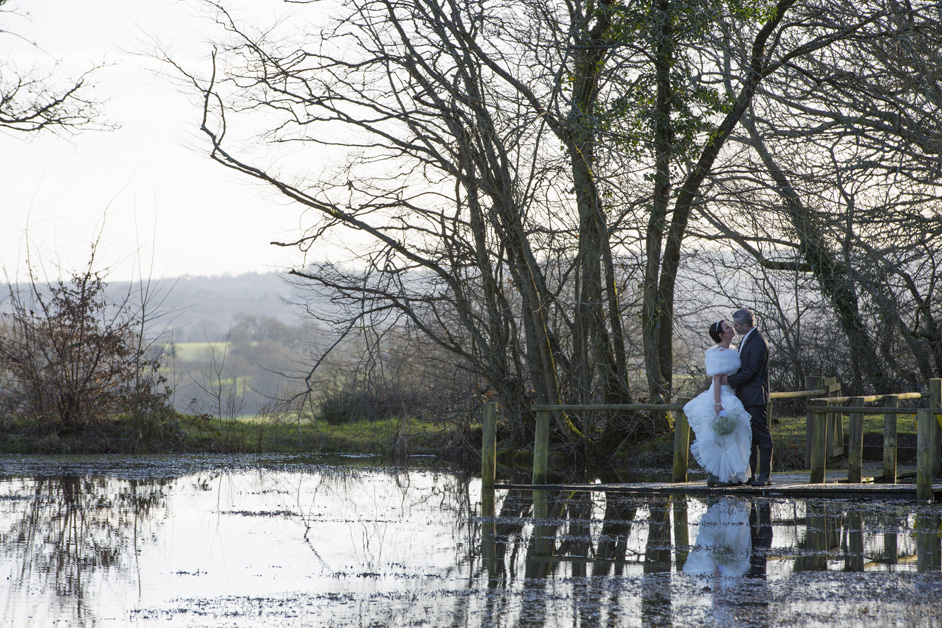 bride and groom sharing a romantic moment by the lake at Swallows Oast, Tunbridge Wells