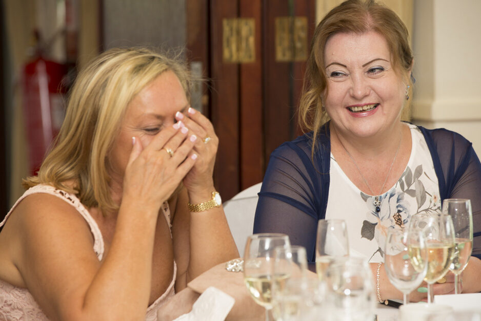 female wedding guests laughing during speeches at The Weald of Kent in Headcorn