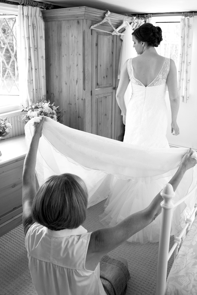 bride's mum helping bride with back of dress at Smarden village home in Kent