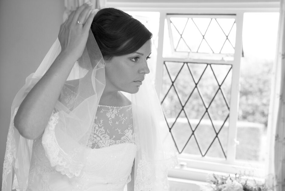 bride checking her veil in a mirror at Smarden village home in Kent