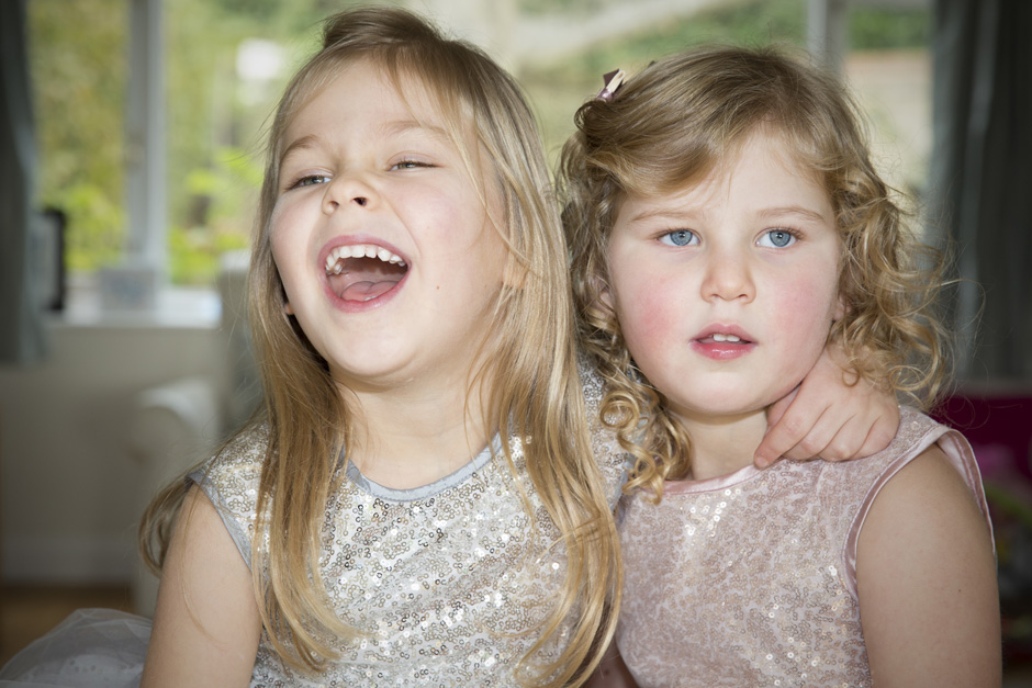 little girls sitting together in sparkly dresses in West Malling, Kent