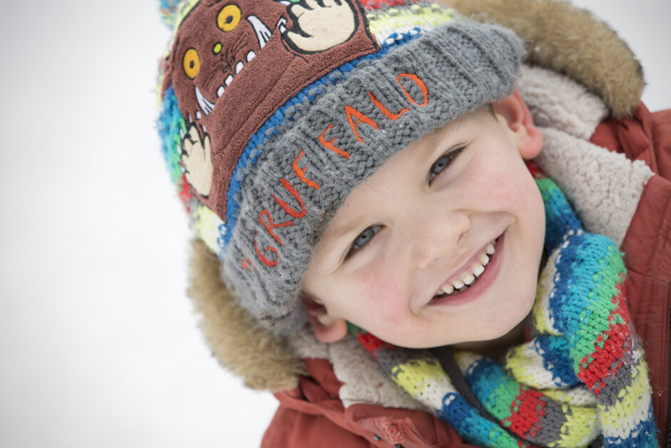 close-up of little boy in scarf and hat in the snow in Tonbridge, Kent