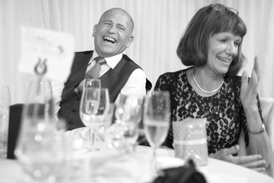 groom's parents laughing during wedding speeches at Smarden village home marquee in Kent
