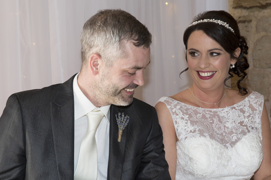 bride and groom laughing during signing of the register at Swallows Oast wedding in Ticehurst, East Sussex