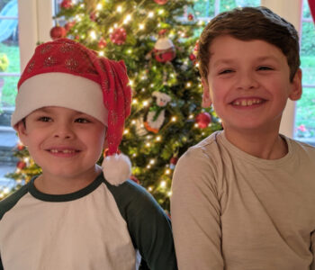 two little boys standing by the christmas tree laughing