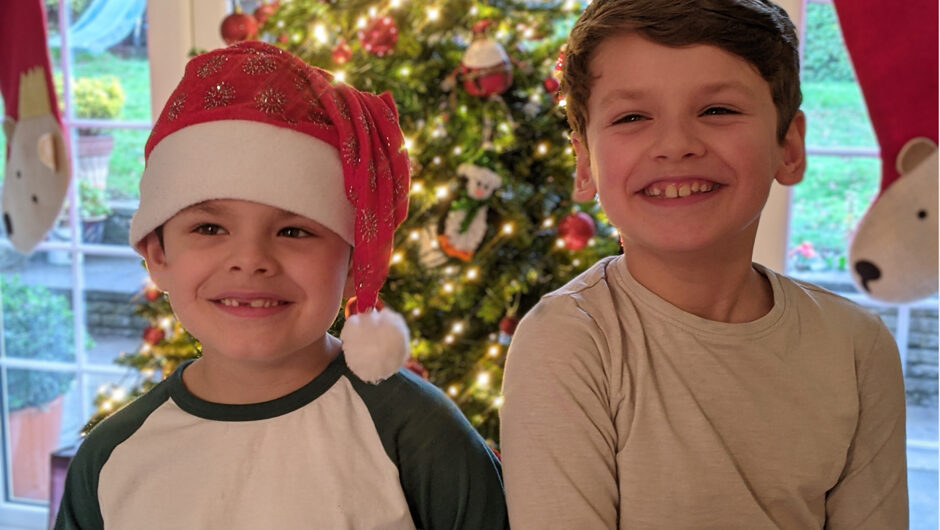 two little boys standing by the christmas tree laughing