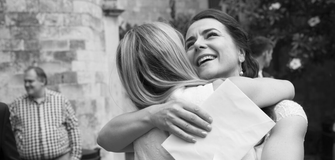 bride shares a loving embrace with a friend at Lewes Register Office in East Sussex. Captured by Kent wedding photographer Victoria Green.