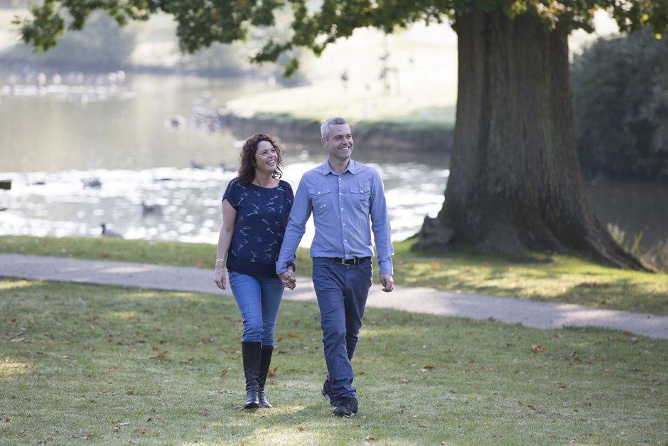 engagement shoot with couple walking through Dunorlan Park with lake in background, Tunbridge Wells in Kent