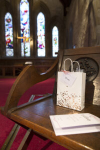 Personalised bags on bride and groom's chair at St Stephen's Church in Tonbridge, Kent.