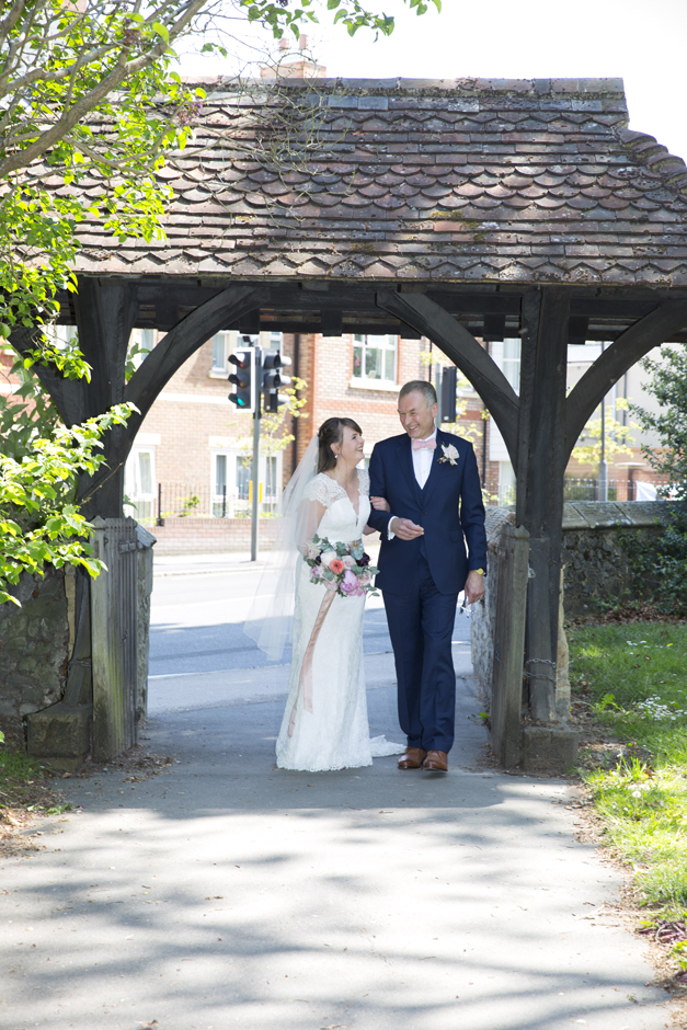 Bride and Father laughing under lynch gate at St Stephen's Church in Tonbridge, Kent