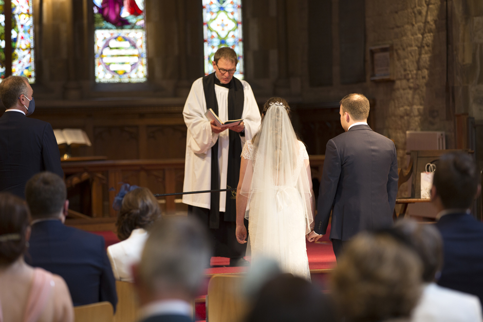 Bride and Groom listening to vicar from behind at St Stephen's Church wedding in Tonbridge, Kent