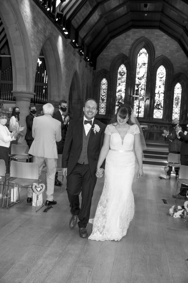 Bride and Groom laughing as guests clap in wedding ceremony at St Stephen's Church in Tonbridge, Kent