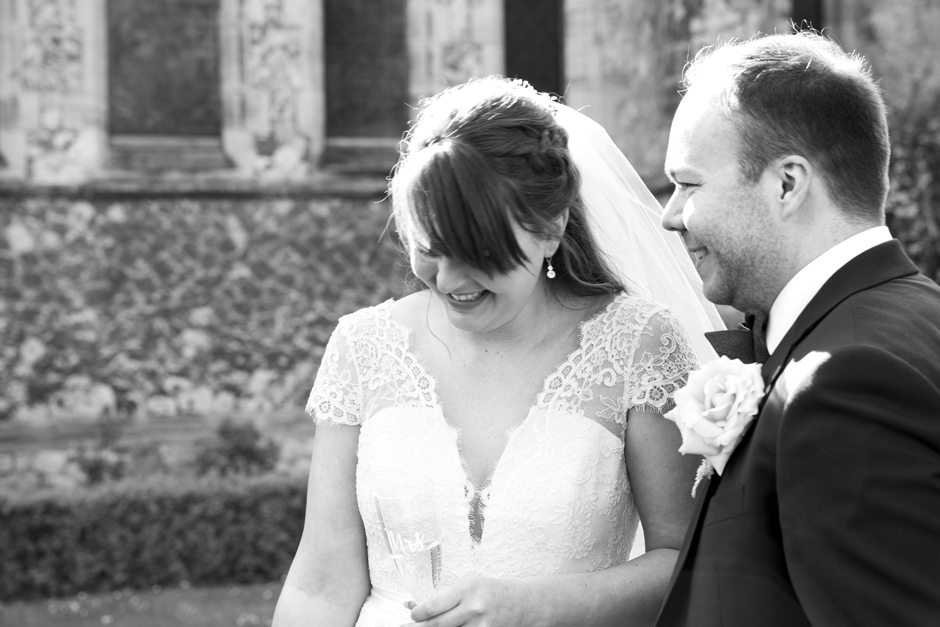 Bride and Groom laughing drinking champagne at St Stephen's Church in Tonbridge, Kent
