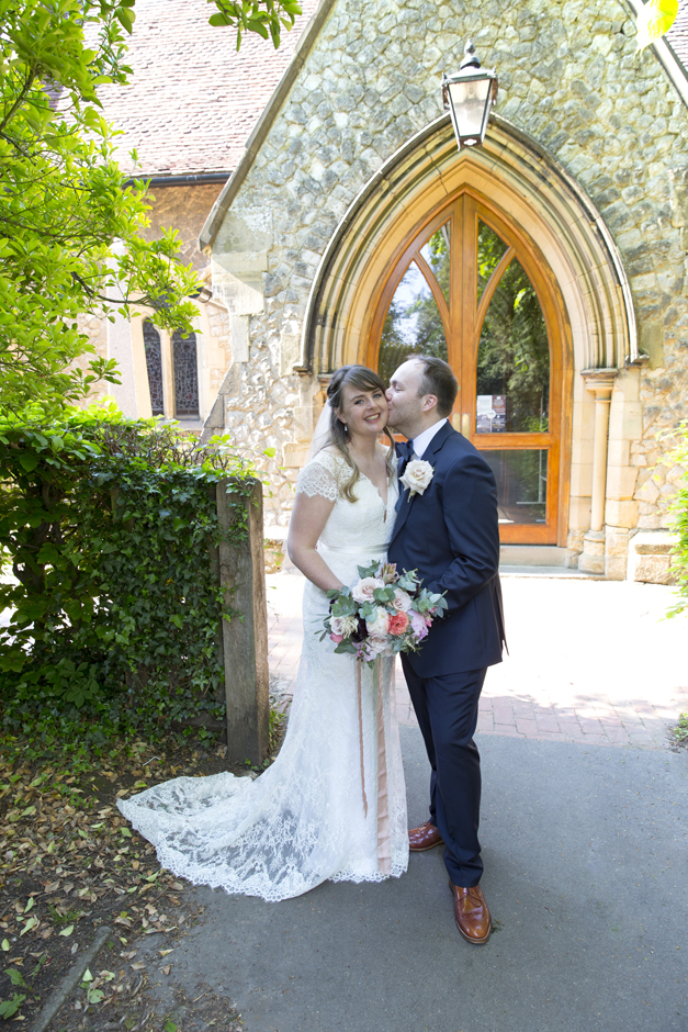 Bride and Groom portrait with groom kissing bride outside St Stephen's Church in Tonbridge, Kent