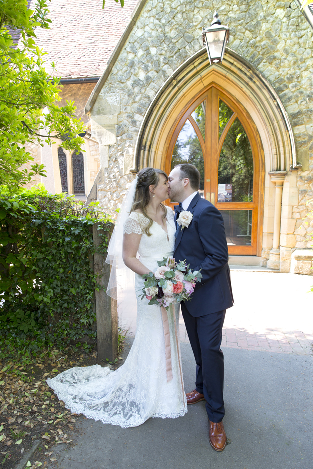 Bride and groom kissing portrait outside St Stephen's Church in Tonbridge, Kent