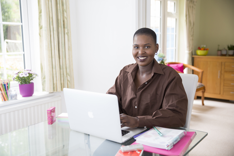 Black business woman at desk on laptop captured by Kent wedding photographer Victoria Green