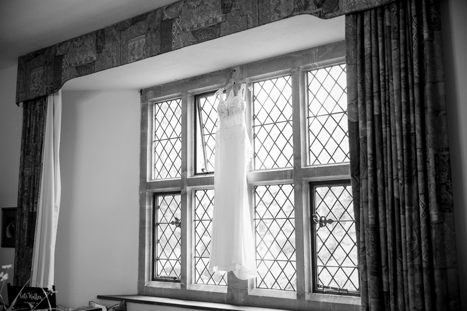 Wedding dress hanging up at window at Nettlestead Place in Maidstone Kent. Captured by Kent wedding photographer, Victoria Green