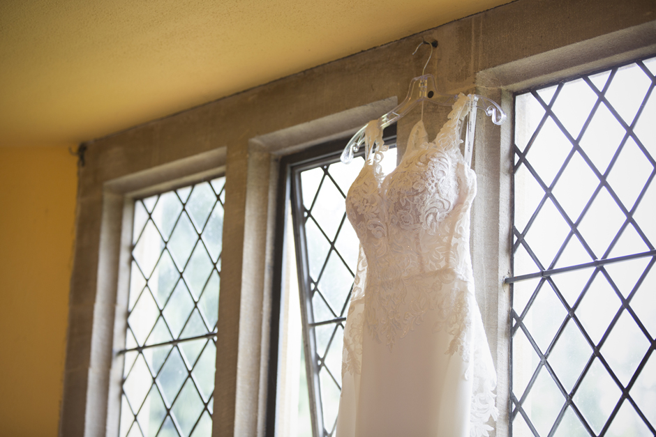 Close-up of wedding dress hanging in the window at Nettlestead Place in Kent. Captured by wedding photographer Victoria Green.