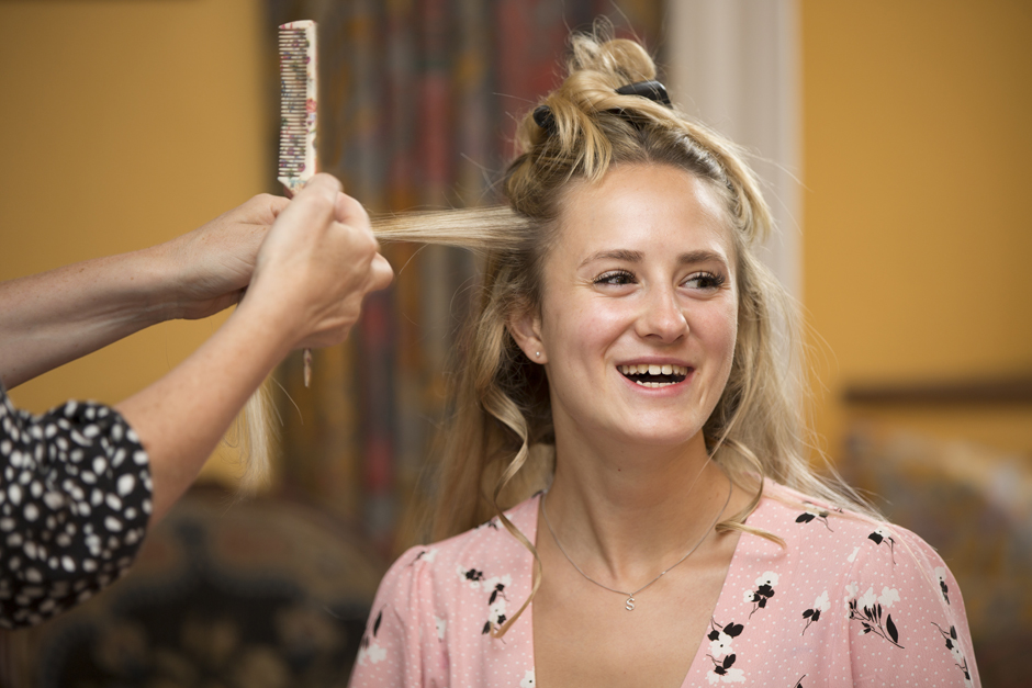 Bridesmaid having hair done, laughing captured by Kent wedding photographer Victoria Green at Nettlestead Place in Maidstone.