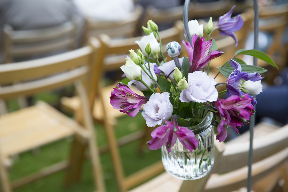 Fresh purple and pink flowers in hanging jam jar at Nettlestead Place outside wedding ceremony. Captured by Kent wedding photographer Victoria Green.
