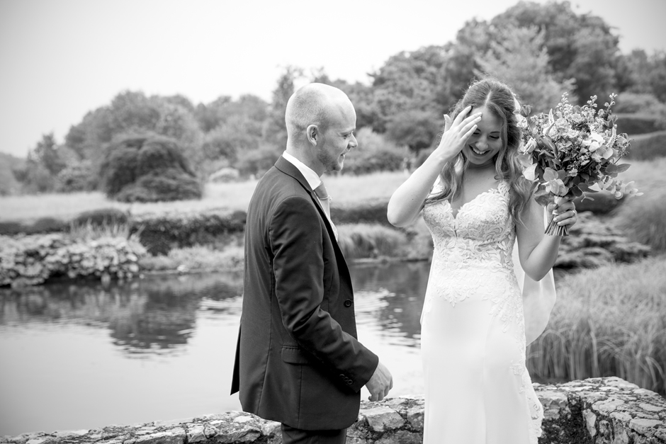 Bride and Groom laughing at Nettlestead Place wedding, standing by the lake, Captured by Kent wedding photographer, Victoria Green.