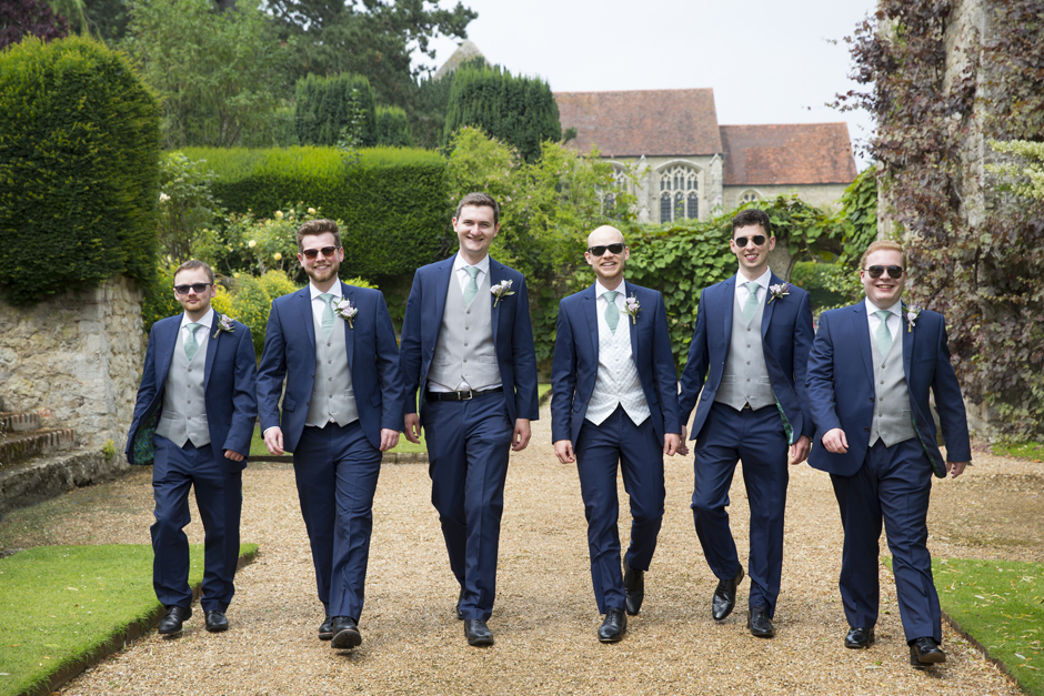 Groom and groomsmen walking at Nettlestead Place wedding. Captured by Kent wedding photographer, Victoria Green.