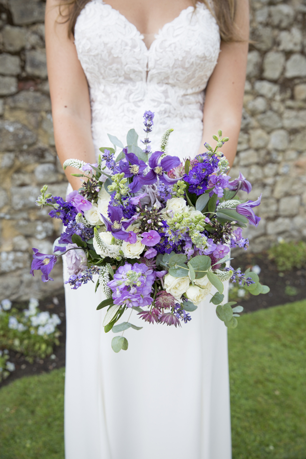 Bride with fresh purple bouquet at Nettlestead Place wedding in Maidstone, Kent.