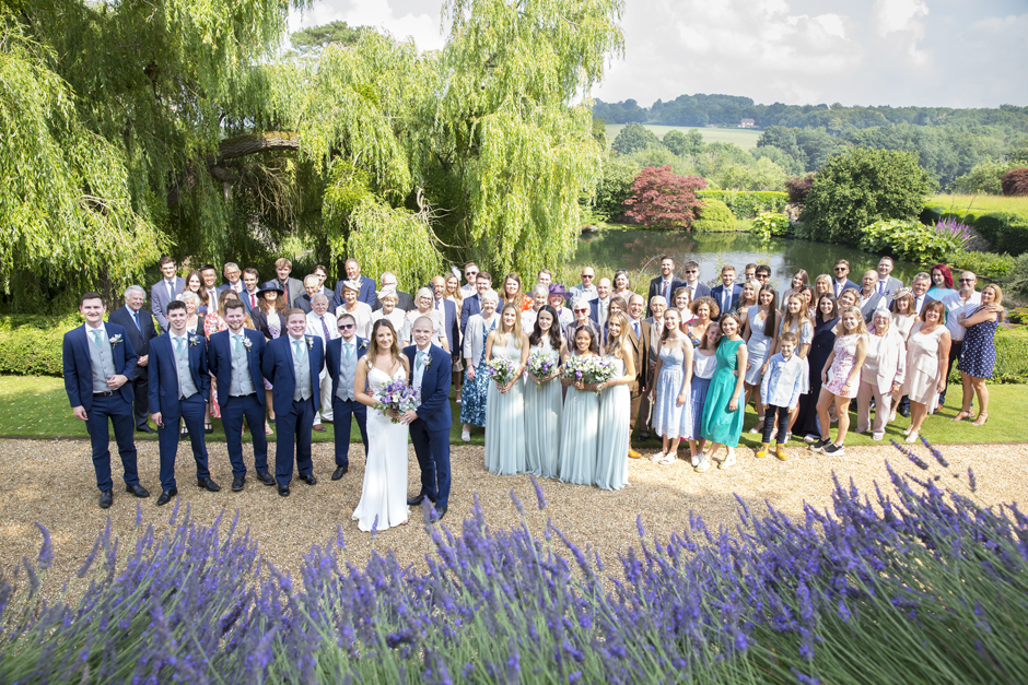 All group portrait of all family and friends with bride and groom captured at Nettlestead Place in Maidstone, Kent by photographer Victoria Green.