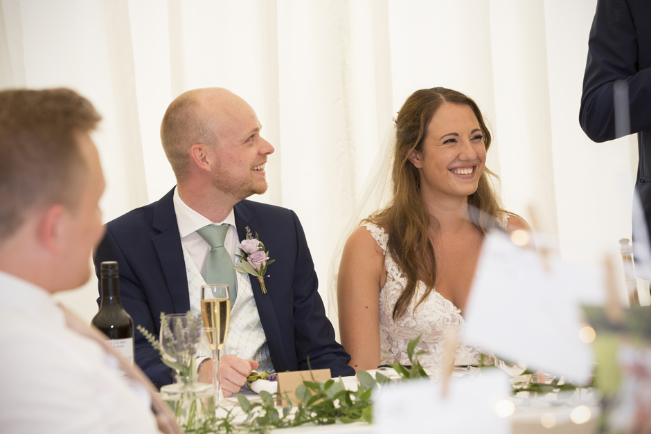 bride and groom laughing during speeches at Nettlestead Place wedding in Maidstone, Kent.