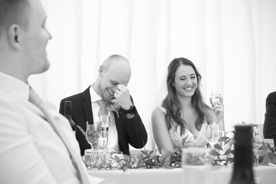 Bride and groom laughing at Nettlestead Place in Maidstone in Kent. Groom looking embarrassed!
