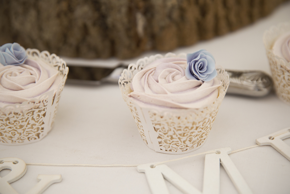 Lilac cupcake with tiny blue rose on top at Nettlestead Place wedding in Maidstone, Kent.