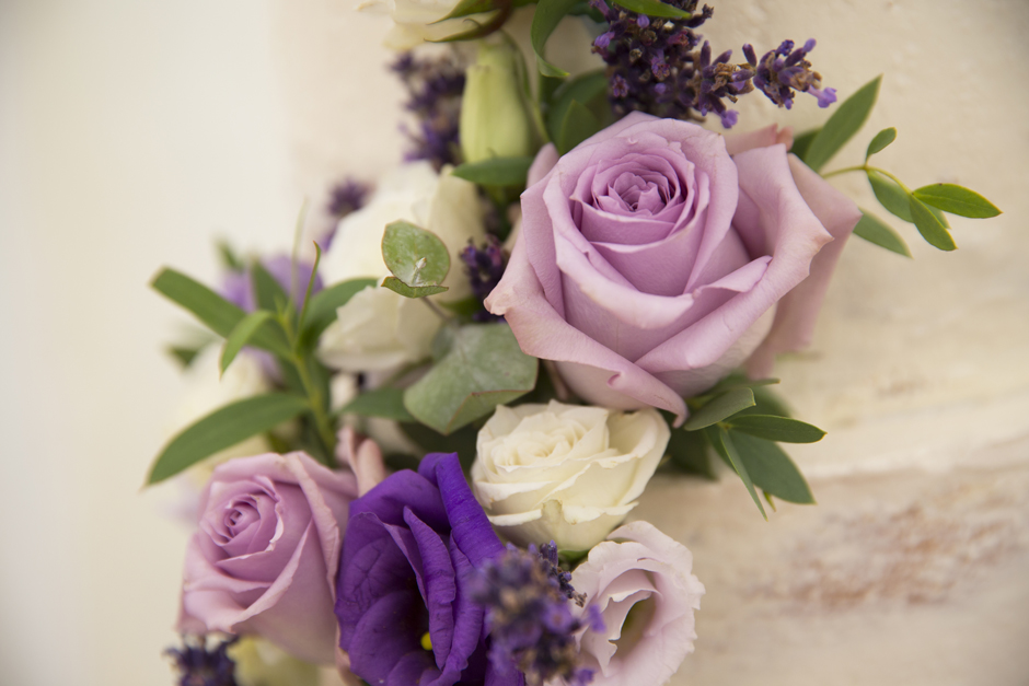Lilac cream and deep purple rose decoration on wedding cake, captured at Nettlestead Place in Kent by photographer Victoria Green.