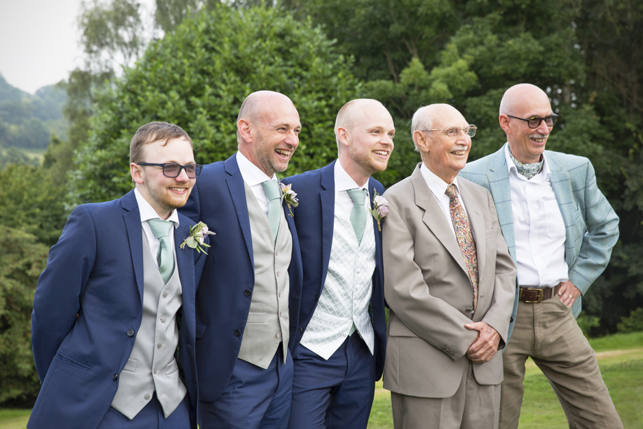 Men from all generations posing for a photograph outside at Nettlestead Place wedding in Maidstone, Kent.