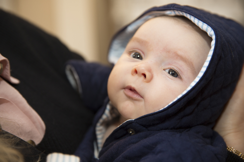 Close-up of baby boy looking to camera during morning bridal prep at Bradbourne House in East Malling, Kent.
