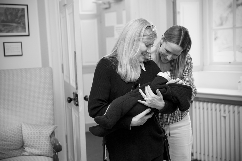 Mother of bride holding baby with mother looking on lovingly during bridal prep morning at Bradbourne House in East Malling, Kent.