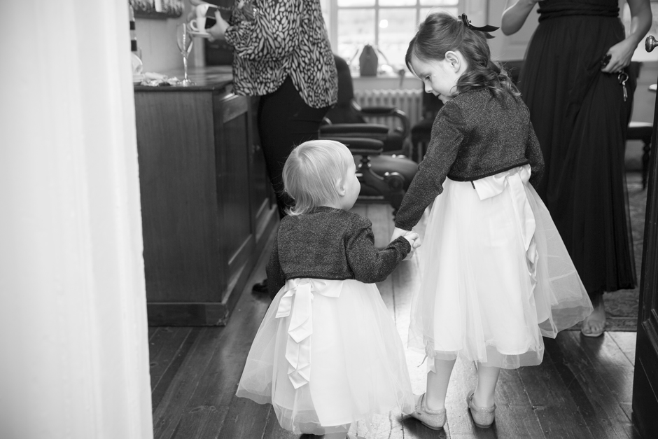 Flower girls holding hands looking at each other during wedding morning bridal prep at Bradbourne House in East Malling, Kent.