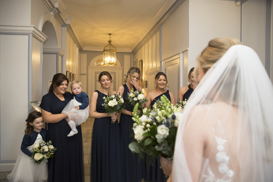 Bridesmaids smiling and laughing after bride reveal during Bradbourne House wedding morning in East Malling, Kent.