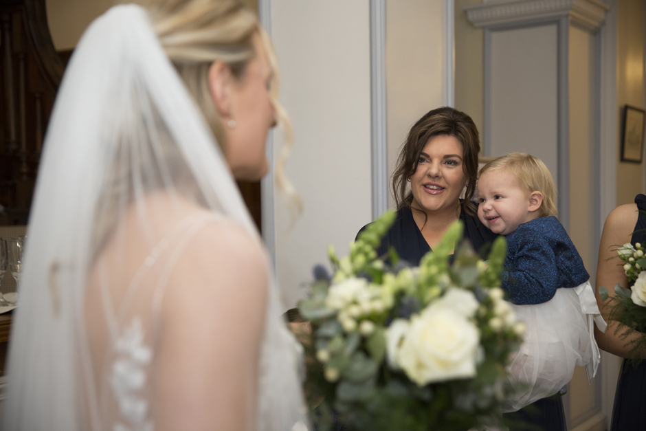 Bridesmaid and her baby looking at bride at Bradbourne House wedding in East Malling, Kent.