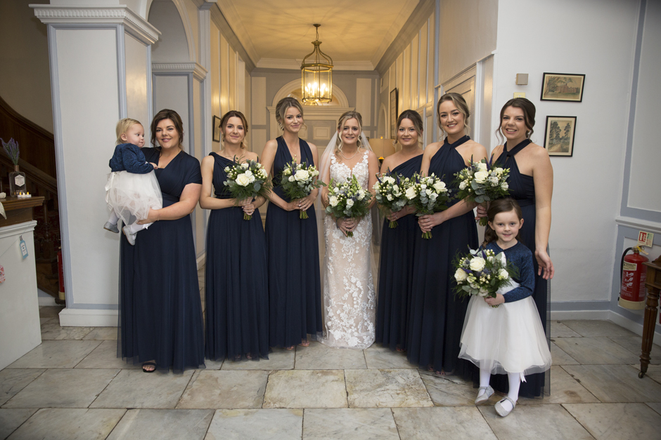 Bride, bridesmaids and flower girls pose for picture before the wedding ceremony at Bradbourne House, East Malling in Kent.