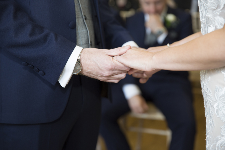 Close-up of Bride and Groom holding hands during wedding ceremony at Bradbourne House in East Malling, Kent.