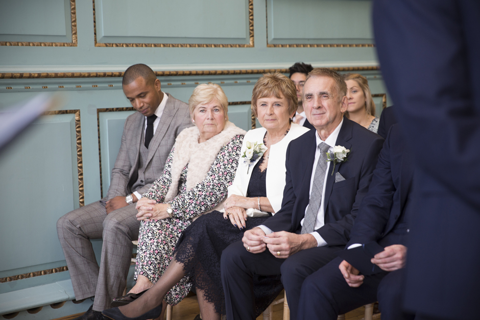 Close-up of Groom's parents and family during wedding ceremony at Bradbourne House in East Malling, Kent.