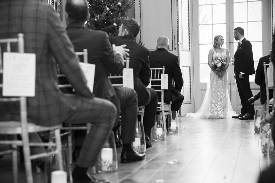 Bride and Groom at front of ceremony room chatting as guests watch on captured at Bradbourne House in East Malling, Kent.