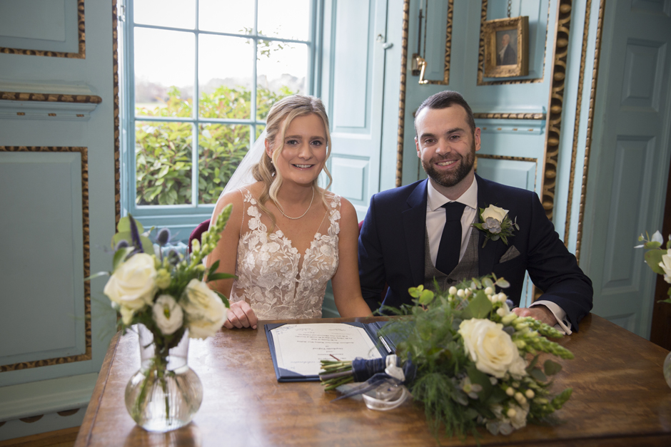 Bride & Groom sitting with register at Bradbourne House wedding ceremony in East Malling, Kent.