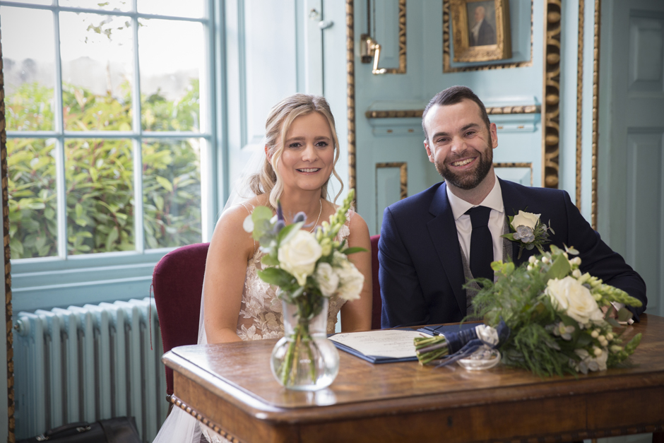 Bride and Groom laughing sitting after signing the register at Bradbourne House wedding in East Malling, Kent.