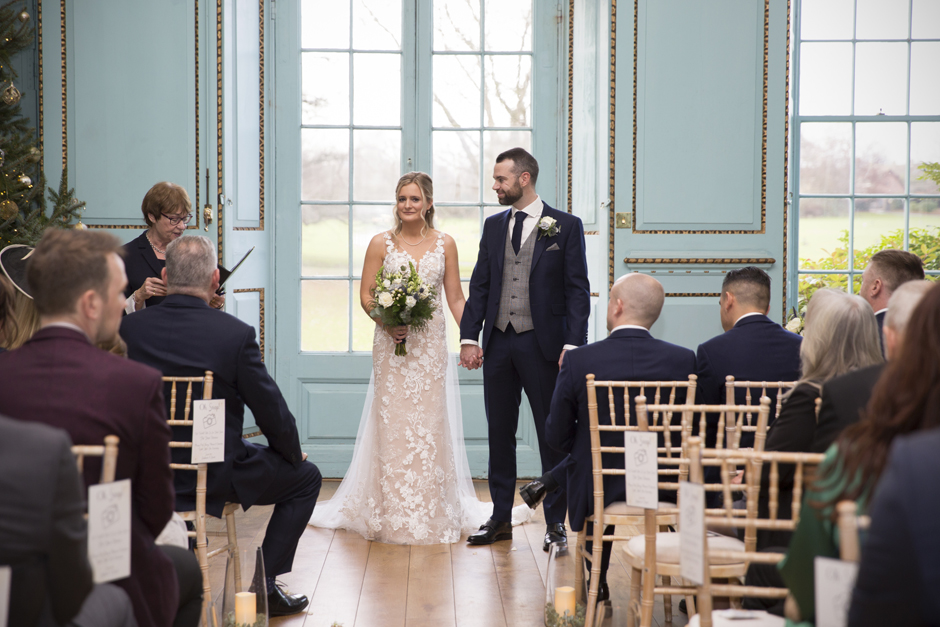 Bride and Groom standing together facing their guests whilst register says final words to end the wedding ceremony at Bradbourne House in East Malling, Kent.