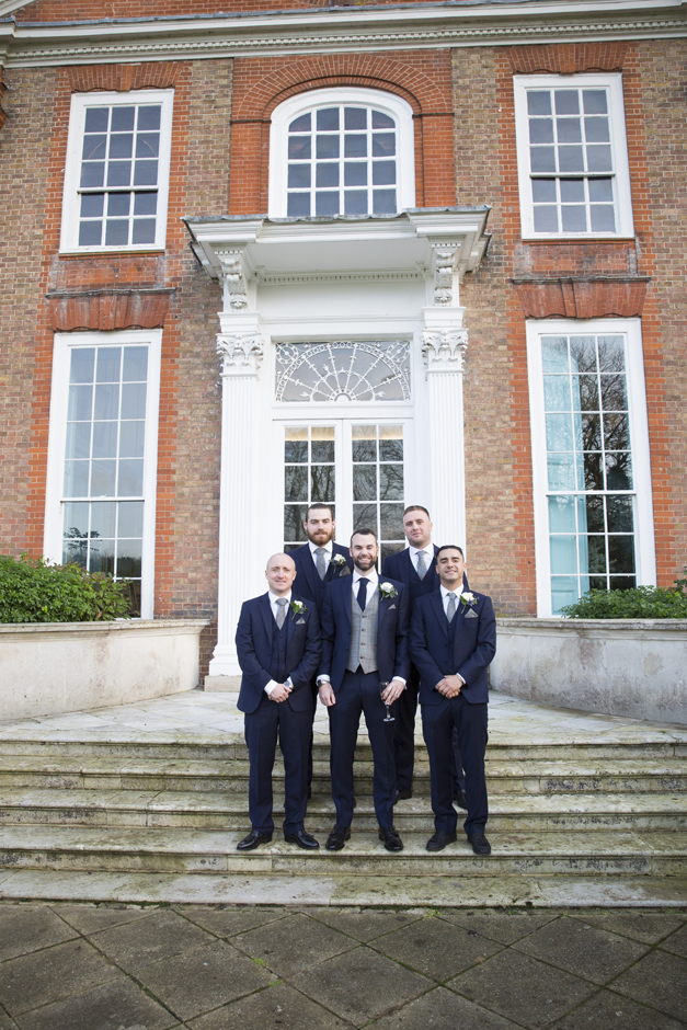 Groom with groomsmen posing on the front steps of Bradbourne House in East Malling, Kent.