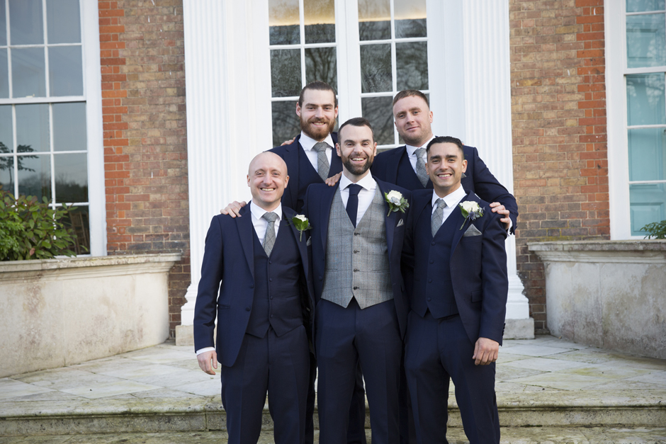 Close-up of groom with groomsmen captured on front steps at Bradbourne House wedding at East Malling, Kent.